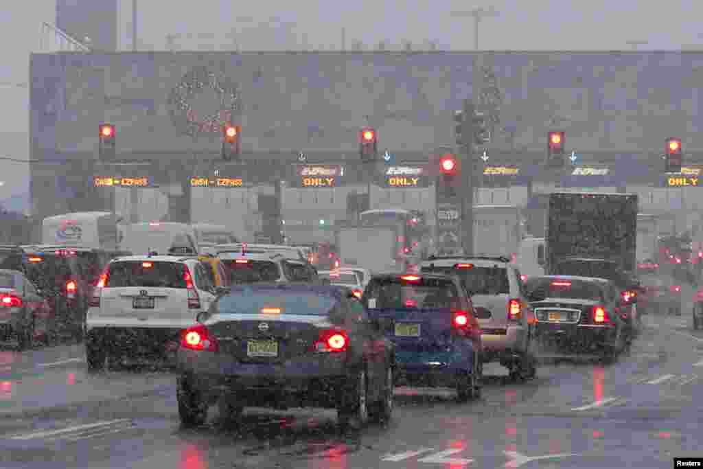 Vehicles wait in line to go through the Holland tunnel to New York City during a snowstorm in Newport, New Jersey, Dec. 10, 2013.