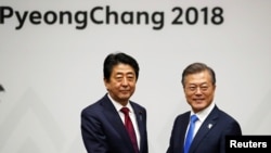 문재인(오른쪽) 한국 대통령과 아베 신조 일본 총리가 지난 9일 평창동계올림픽 개막 행사장 인근에서 만나 악수하고 있다. 