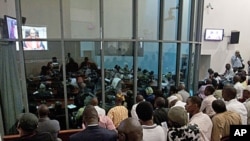 People watch a live broadcast of the verdict in the Netherlands-based trial of former Liberian president Charles Taylor, at the Special Court for Sierra Leone, in Freetown, Sierra Leone, April 26, 2012.