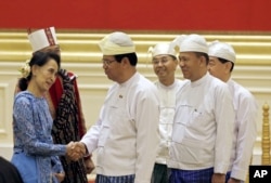 Aung San Suu Kyi, left, greets members of Myanmar's old cabinet during a presidential handover ceremony in Naypyitaw, Myanmar, March 30, 2016.