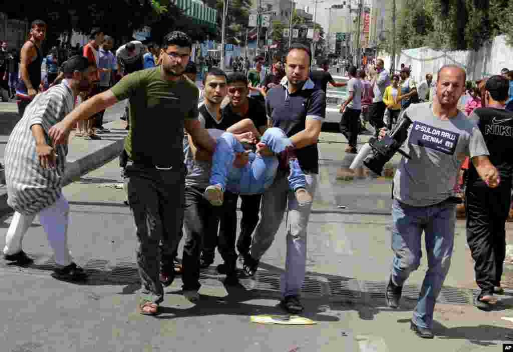 Palestinians carry a person killed in a blast outside a U.N.-run school in Rafah, in the southern Gaza Strip, Aug. 3, 2014.