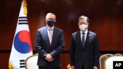 South Korean President Moon Jae-in, right, poses for a photo with Australian opposition Labor Party leader Anthony Albanese in Sydney, Dec. 14, 2021.