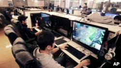 Shin Minchul, bottom, a 21-year-old college student, plays online computer games at an Internet cafe in Seoul, South Korea, Wednesday, Dec. 11, 2013.