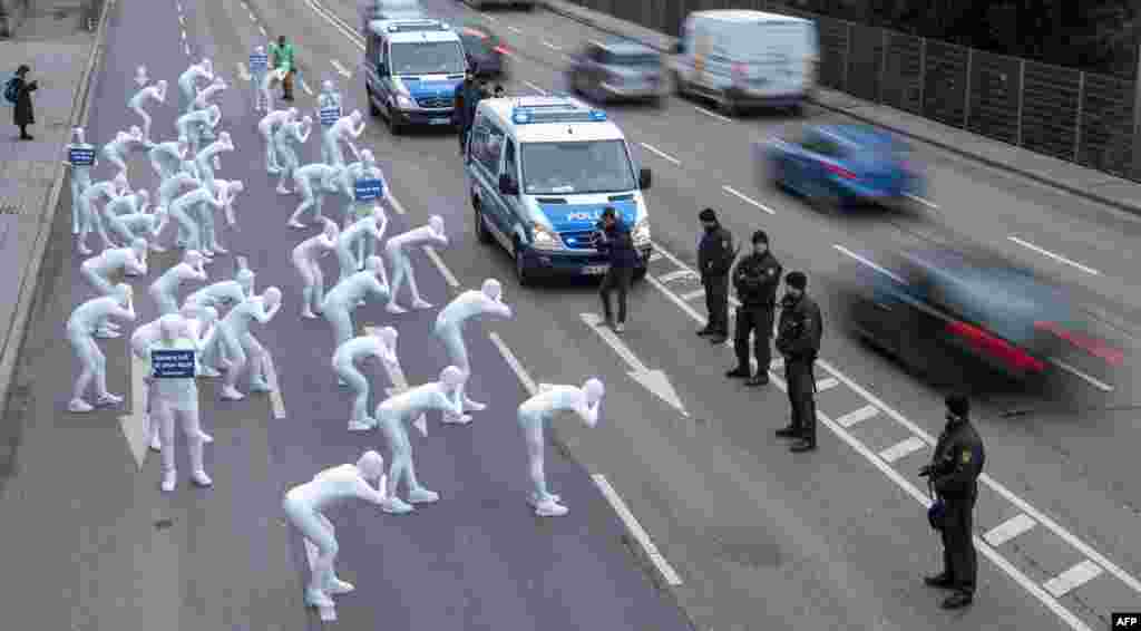 Greenpeace activists wear white morphsuits as they stage an action against particulate matter and health burden caused by diesel exhaust in Stuttgart, southern Germany.