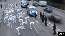 FILE - Greenpeace activists wear white morphsuits as they stage an action against particulate matter and health burden caused by diesel exhaust in Stuttgart, southern Germany, Feb. 19, 2018.