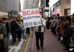 A pro-democracy protester displays a sign during a demonstration in Hong Kong to demand genuine universal suffrage, March 25, 2017.