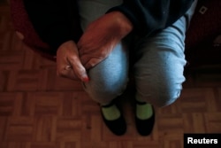 FILE - Susana Reyes sits in her living room. Reyes suffered a thrombosis attack in April 2012 which left her left hand and left leg partially paralyzed.