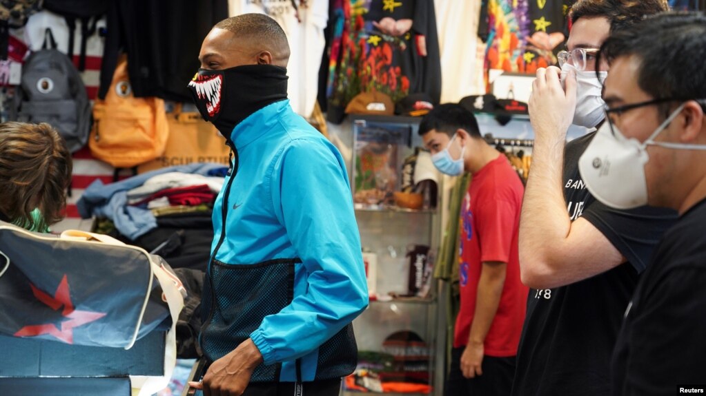 Klientët dhe punonjësit mbajnë maska në dyqanet e rihapura në Teksas