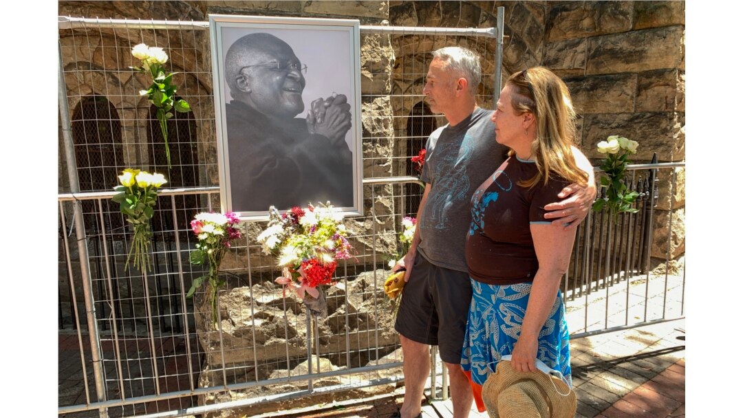 Mourners look at a portrait of South African anti-apartheid icon Desmond Tutu outside St. George's cathedral in Cape Town on Dec. 26, 2021, after the news of Tutu's passing.