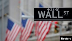 FILE - A sign for Wall Street is seen outside the New York Stock Exchange in Manhattan, N.Y.