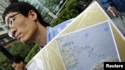 A South Korean activist holds a map of Dokdo islets during a rally denouncing Japan's sovereignty claim on the islets, in front of the Japanese Embassy in Seoul, September 10, 2010.