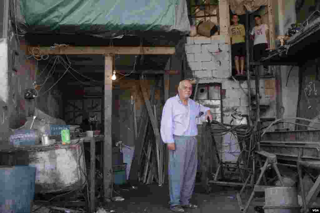 Mechanic Imad Suleiman lives on site with his two grandchildren at the truck stop in Lebanon’s Bekaa region. With trucks coming in for repair, he cannot afford to put them in school. (John Owens/VOA)