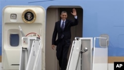 President Barack Obama waves upon arrival to Cartagena, Colombia, April 13, 2012.