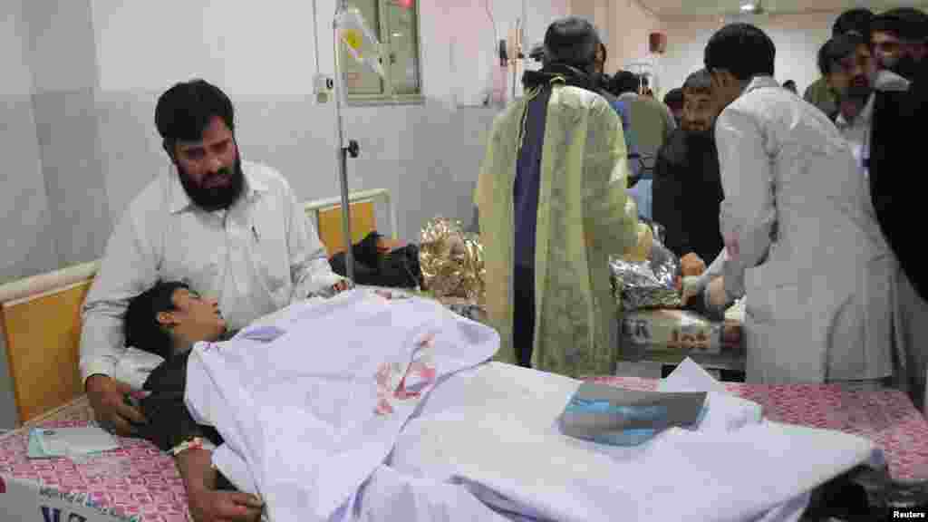 Un homme réconforte son fils, qui a été blessé lors d&#39;une attaque par des hommes armés talibans sur l&#39;école publique de l&#39;Armée, à l&#39;hôpital Lady Reading à Peshawar, au Pakistan, le 16 décembre 2014.