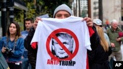FILE - A street vendor sells an anti-President Trump T-shirt during a protest outside Los Angeles City Hall, in Los Angeles, California, Feb. 20, 2017.