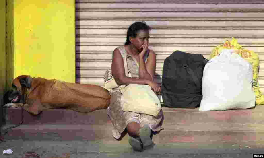 A woman waits with her dog after the government announced a Tsunami warning in Colombo, Sri Lanka. (Reuters)