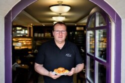 Pembuat manisan Hungaria Zsolt Karl memamerkan "Bite of Heaven" yang disajikannya menjelang kedatangan Paus, di toko kuenya di Dunaharaszti, Hungaria, 7 September 2021. (REUTERS/Marton Monus)