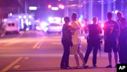 Police officers direct family members away from a fatal shooting at Pulse Orlando nightclub in Orlando, Fla., June 12, 2016. (AP Photo/Phelan M. Ebenhack) 