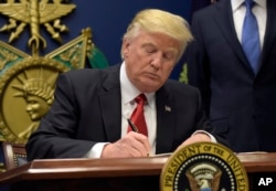 President Donald Trump signs an executive order on extreme vetting during an event at the Pentagon in Washington, Jan. 27, 2017.