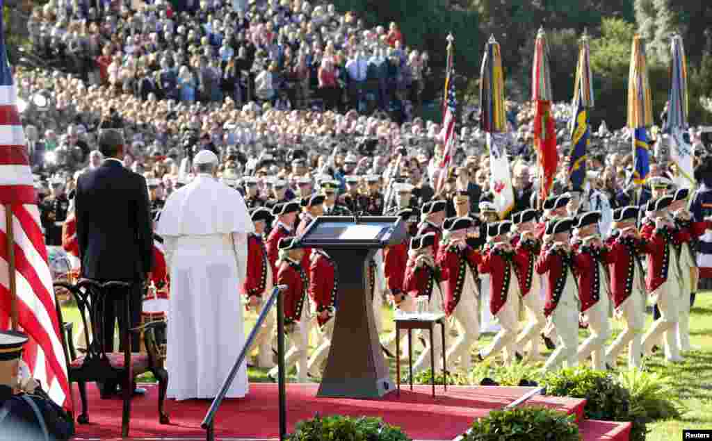 U.S. President Barack Obama and Pope Francis watch onstage as the &quot;Old Guard&quot; fife and drum corps marches past during an official welcome ceremony on the South Lawn of the White House, Sept. 23, 2015.