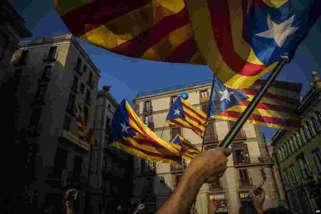 تکان دادن پرچم کاتالونیا توسط طرفدارانش پس از سخنرانی رئیس دولت منطقه ای کاتالونیا در بارسلون اسپانیا