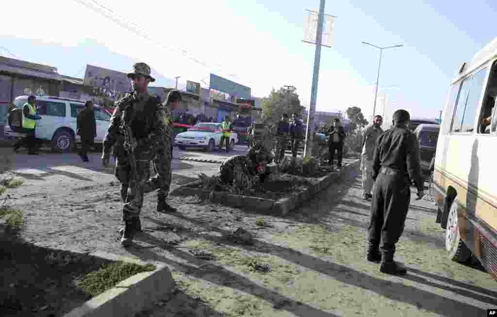 Afghan security forces inspect the site of a roadside bomb explosion which destroyed a mini bus, in Kabul, Afghanistan, Oct. 21, 2014. 