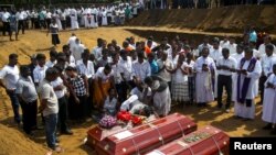 People react during a mass burial of victims, two days after a string of suicide bomb attacks on Easter Sunday, at a cemetery near St. Sebastian Church in Negombo, Sri Lanka, April 23, 2019. (REUTERS/Athit Perawongmetha)