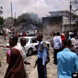 People mill around the scene where a suicide attack took place in Somalia's capital Mogadishu, October 4, 2011.