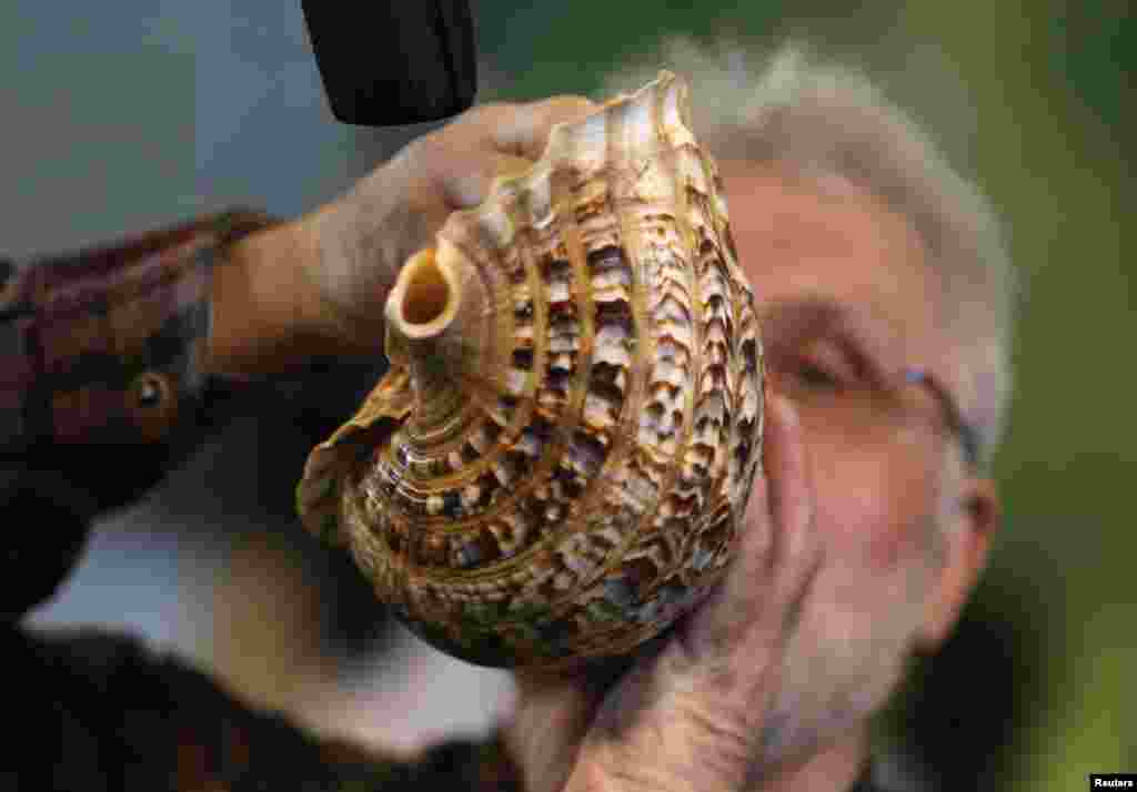 A competitor calls with a shell at the German championships in deer-calling at the "Jagd & Hund" (hunting & dog) exhibition in Dortmund. Competitors use specially designed instruments or ox horns to imitate the mating call of red deers.