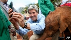 U.S. Secretary of State John Kerry takes a selfie with a baby elephant while touring the Sheldrick Center Elephant Orphanage at the Nairobi National Park, Sunday, May 3, 2015, in Nairobi, Kenya. 