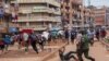 Un officier de police poursuit des vendeurs de rue à Kampala, en Ouganda, le 26 mars 2020. (Photo: Badru KATUMBA / AFP)