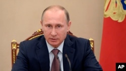 Tổng thống Nga Vladimir Putin tại một cuộc họp nội các ở điện Kremlin. Sự hợp tác giữa Nga và Tây phương phần lớn đã bị gián đoạn sau khi Moscow bị chế tài hồi năm ngoái vì sáp nhập bán đảo Crimea của Ukraine và hỗ trợ cho phe đòi ly khai ở miền đông Ukraine.