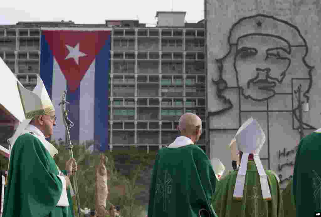 Papa Francis awasili kuongoza Misa kwenye uwanja maarufu wa Mapinduzi Havana, akipeana uso na sanamu ya shuja wa mapinduzi Ernesto "Che" Guevara na bendera ya Cuba iliyopambwa kwenye jengo la serikali, Sept. 20, 2015.