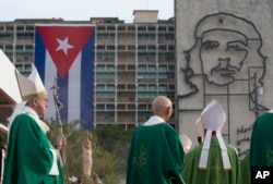 Pope Francis holds his pastoral staff as he arrives to celebrate Mass at Revolution Plaza in Havana, Cuba, where a sculpture of revolutionary hero Ernesto "Che" Guevara and a Cuban flag decorate a nearby government building, Sept. 20, 2015.