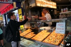 file - A worker serves a customer at a fast food outlet in central London, Britain, September 25, 2017.