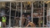 Sri Lankan police clear the area while Special Task Force Bomb Squad officers inspect the site of an exploded van near a church that was attacked yesterday in Colombo, April 22, 2019. 