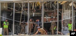 A Sri Lankan Police officer inspects a blast spot at the Shangri-la hotel in Colombo, Sri Lanka, Sunday, April 21, 2019.