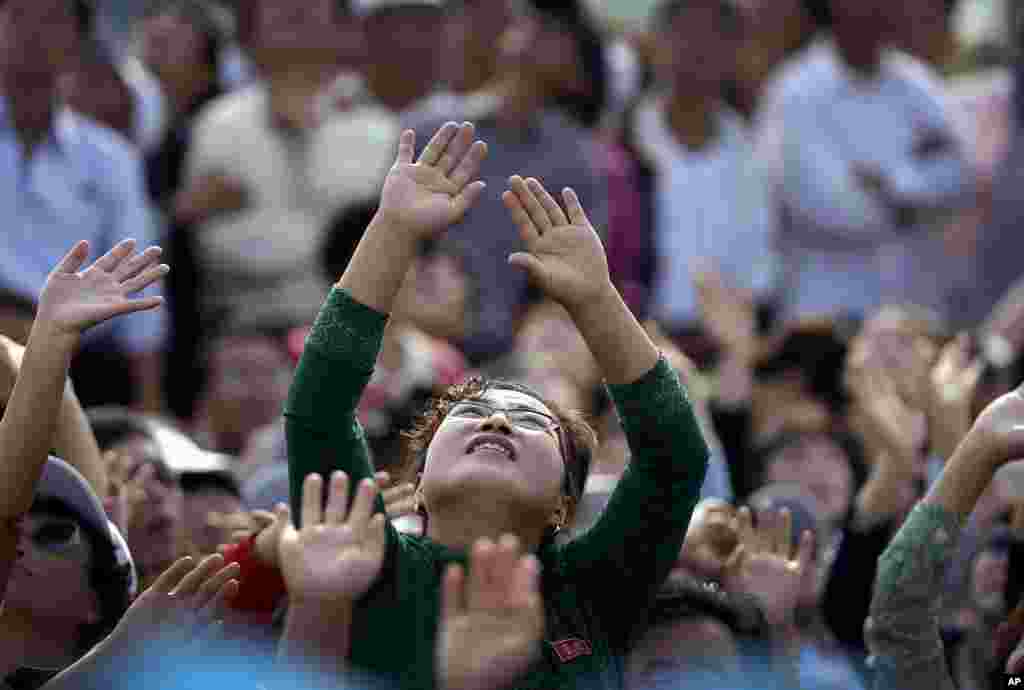지난 9월 25일(현지시간) 원산 갈마비행장 &#39;원산 국제친선 항공축전-2016&#39; 현장에 나온 관객들이 낙하산 시범을 향해 손을 흔들고 있다.