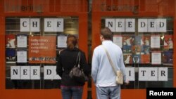 Pedestrians read recruitment announcements in central London October 15, 2008. British unemployment shot up at its fastest pace since the early 1990s recession this summer and experts are predicting even bigger rises ahead as the financial crisis takes it