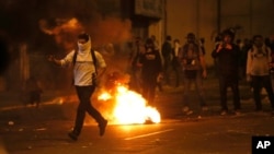A demonstrator runs to confront a line of Bolivarian National Guard officers during anti-government protests in Caracas, Venezuela, Feb. 28, 2014.