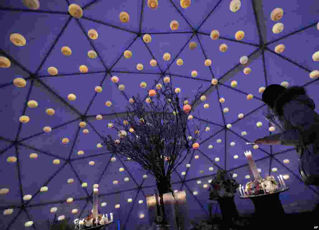 A woman lights candles during an event for the victims of the March 11, 2011 earthquake and tsunami in Tokyo. Japan marked the second anniversary of the devastating earthquake and tsunami that left nearly 19,000 people dead or missing.