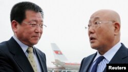 Japanese Cabinet Secretariat Advisor Isao Iijima (R) is greeted by Kim Chol-ho, vice director of the North Korean Foreign Ministry's Asian Affairs Department, upon his arrival Pyongyang airport, May 14. 2013.