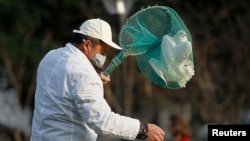 Petugas taman kota Shanghai menangkapi burung-burung merpati untuk mencegahnya merebaknya flu burung di sana (6/4). 