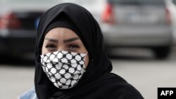 Žena u izbegličkom kampu u Libanu nosi maramu za lice sa motivom palestinske marame.