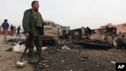 Un combatiente kurdo monta guardia un área dañada por una bomba del grupo Estado islámico.