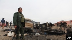 一名库尔德武装人员站在遭伊斯兰国组织炸弹袭击的现场