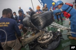 Rescuers use crane to retrieve part of the landing gears of the crashed Lion Air jet from the sea floor in the waters of Tanjung Karawang, Indonesia, Sunday, Nov. 4, 2018.