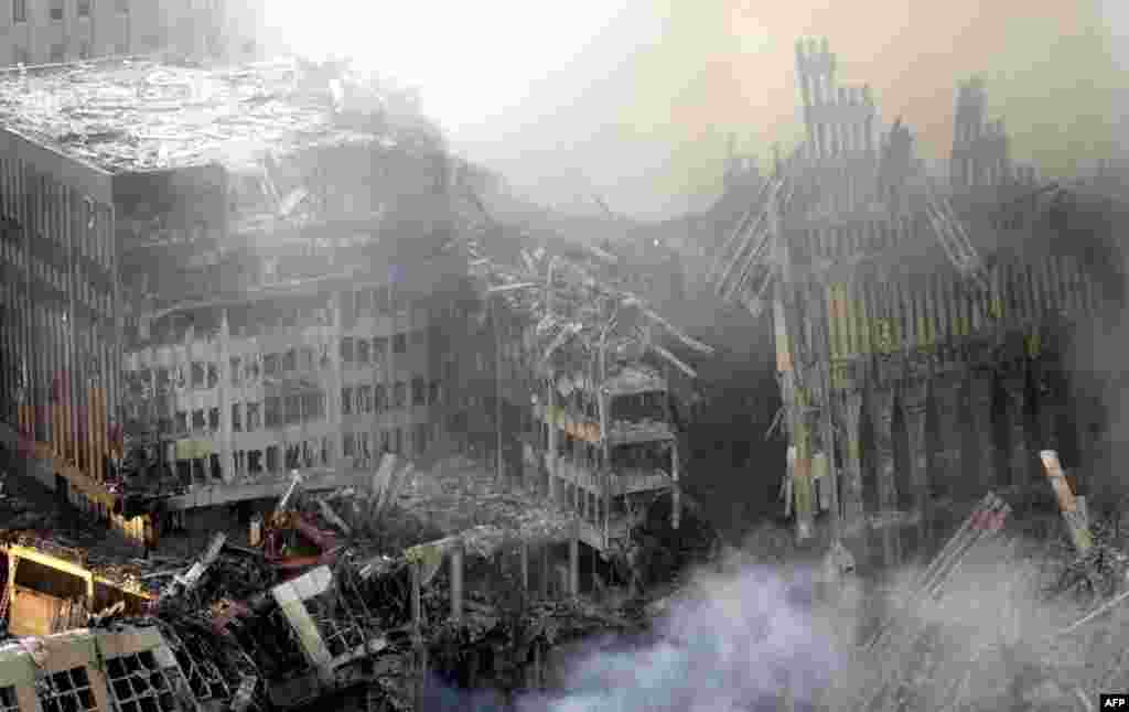 (FILE) Early morning light falls on the the debris and smoke of the World Trade Center twin towers collapse early 12 September, 2001 in New York City. Rescue efforts at the site are underway. Both towers of the World Trade Center collapsed after hijacked airliners collided with them 11 September. AFP PHOTO/Marcos TOWNSEND (Photo by MARCOS TOWNSEND / AFP)