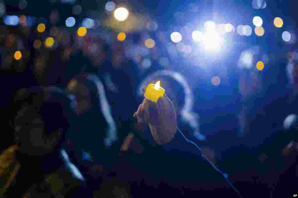 A man holds a candle during an interfaith vigil for peace in response to Manhattan Attack at Foley square, Nov. 1, 2017, in New York.