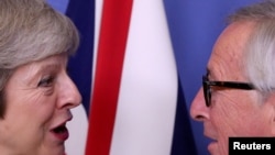 FILE - British Prime Minister Theresa May meets with European Commission President Jean-Claude Juncker to discuss Brexit, at the EU headquarters in Brussels, Dec. 11, 2018.